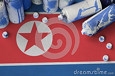 North Korea flag and few used aerosol spray cans for graffiti painting. Street art culture concept Stock Photo