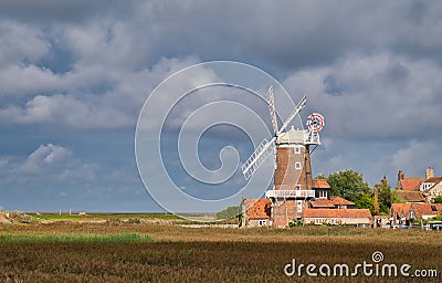 From the North Norfolk Coast Path, a view across the coastal wetlands and the Grade 2 listed tower mill at Cley next the Sea. Editorial Stock Photo
