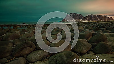 The norther lighfs over the cloud on a beach full of rocks Stock Photo