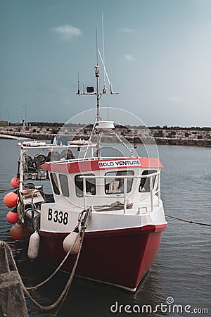 NORTHERN IRELAND, UK - 8TH APRIL 2019: A bright red fishing boat called Bold Venture is moored at a port in Ireland Editorial Stock Photo