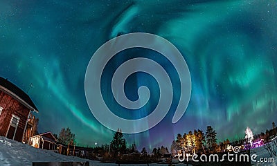 Northern Lights in the clear starry skies shines above Swedish countryside in Northern landscape. Green and blue Aurora Borealis Stock Photo