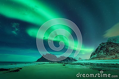 Bright aurora, sea, sandy beach and snowy mountains Stock Photo