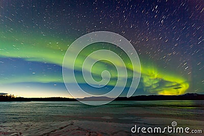 Northern Lights and morning dawn over frozen lake Stock Photo