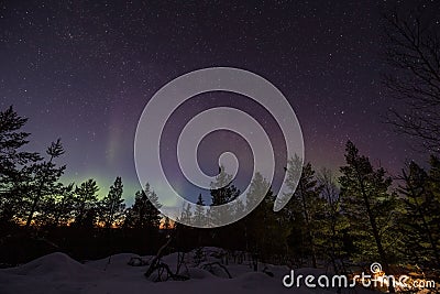 Northern lights over a forest in the hills of Inari, Finland Stock Photo