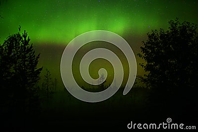 Northern lights over oncoming fog in the night Stock Photo