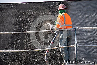 A construction worker sprays concrete on a wall at a work site at 9123 Shirley Ave. Editorial Stock Photo