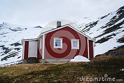 Norway countryside. Classic red wooden houses near mountains. Spring time. Norwegian cottage. Stock Photo