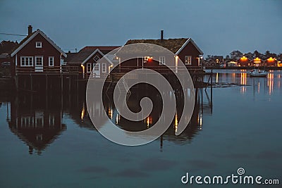 Norway rorbu houses and mountains rocks over fjord landscape scandinavian travel view Lofoten islands. Night landscape. Stock Photo