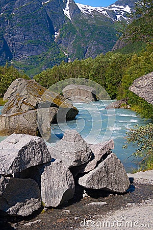 Norway. Water flow from the thawing glacier Briksdayl in mountains in the summer afternoon Stock Photo