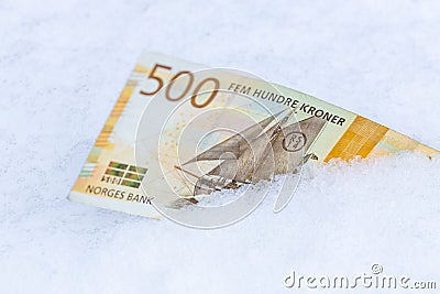Norwegian 500 kroner lying in the snow, Financial concept, spending freeze Stock Photo