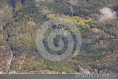 Norwegian fjord landscape with waterfall and houses. Sorfjorden. Norway. Stock Photo