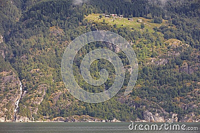 Norwegian fjord landscape with waterfall and houses. Sorfjorden. Norway. Stock Photo