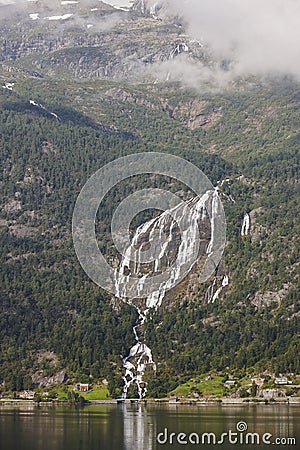 Norwegian fjord landscape with waterfall and houses. Sorfjorden. Norway. Stock Photo