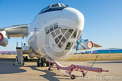 The nose and front of the cockpit of a military transport cargo aircraft, towing and taxiing carriers in front of the landing gear Stock Photo