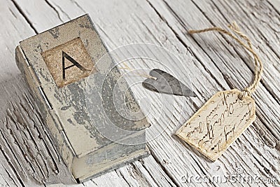 Nostalgic still life with little tin box with letter A and heart Stock Photo