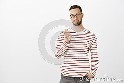 Not bad, like your idea, good job. Satisfied impressed attractive mature guy in glasses and striped clothes, showing ok Stock Photo