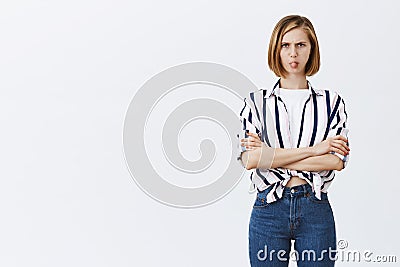 Not gonna talk to you, I am angry. Cute and funny caucasian adult female in striped blouse being childish, frowning and Stock Photo
