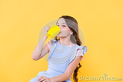 Not my cup of tea. Making sip. Drink enough water. Girl kid hold mug yellow background. Lovely child hold mug. Drinking Stock Photo