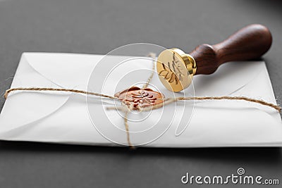 Notary public wax stamper. White envelope with brown wax seal, golden stamp. Responsive design mockup, flat lay. Still life with Stock Photo