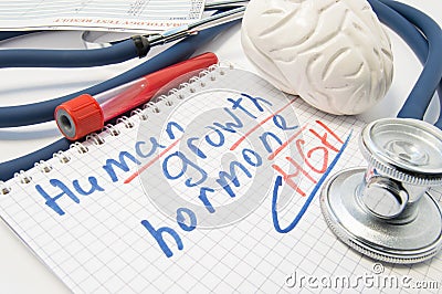 Note inscribed with Human Growth Hormone HGH or Somatotropin is surrounded by laboratory test tube with blood, brain figure and Stock Photo