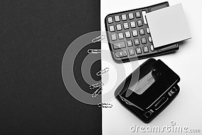 Note paper, hole punch and paper clips on white surface. Business and work concept: stationery and calculator on white Stock Photo
