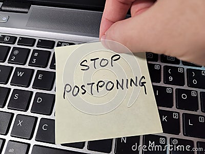 A note showing the phrase Stop Postponing Stock Photo