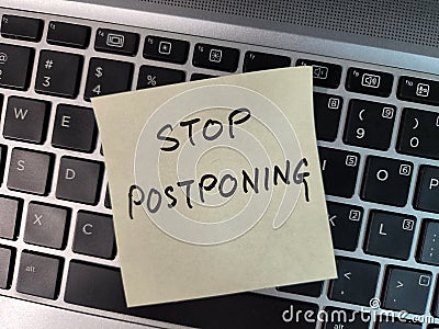 A note showing the phrase Stop Postponing Stock Photo