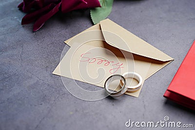 Note with the sorry word next to a wedding ring. Stock Photo