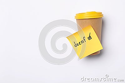 Note with word Decaf and checkbox attached to takeaway coffee cup on white background, top view. Space for text Stock Photo