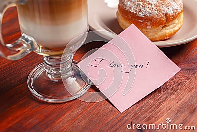 A note with the words `I love you` and a Cup of cappuccino Stock Photo