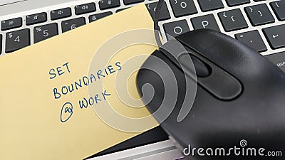A note with the words Set Boundaries At Work placed on a keyboard. Stock Photo