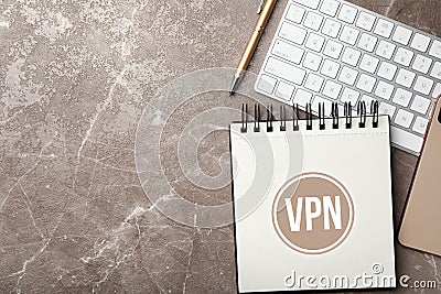 Notebook with acronym VPN and space for text on brown marble table, flat lay. Secure network connection Stock Photo