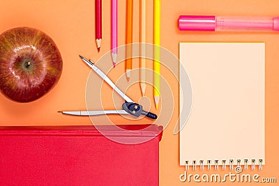 Notebook, book, compass, color pencils and apple on pink background Stock Photo