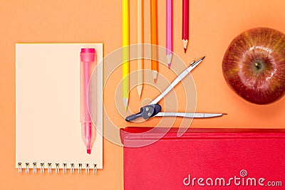 Notebook, book, compass, color pencils and apple on pink background Stock Photo