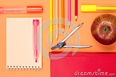 Notebook, book, compass, color pencils and apple on pink background Stock Photo