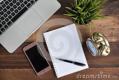 Notebook, laptop, clock, smartphone and pen on a wooden table Stock Photo