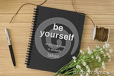 Notebook with wisdom quote and laptop on wood background. Stock Photo