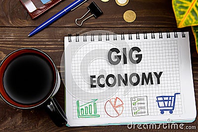 Notebook with a notes GIG ECONOMY on the office table with tools Stock Photo