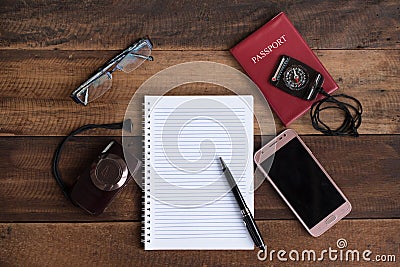 Notebook, passport, camera, compass and smarphone on a wooden table Stock Photo