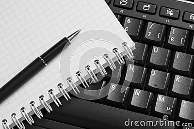 Notebook and pen on the black keyboard. Stock Photo