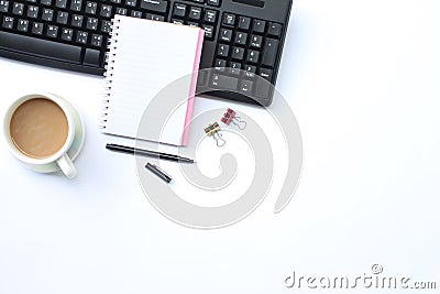 Notebook,pen,keyboard and coffee mug placed on a white desk In t Stock Photo