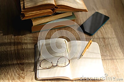 Notebook, Pencil, Glasses, Phone and Books Stock Photo