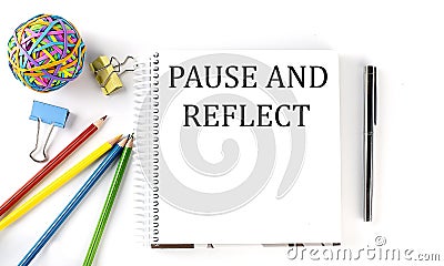 Notebook ,pencils,pen and rubber band with text PAUSE AND REFLECT on the white background Stock Photo