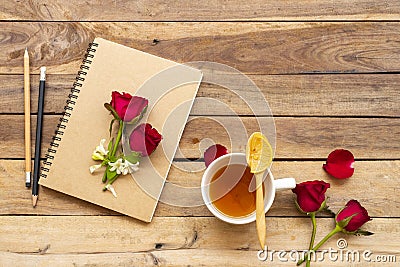 Notebook planner for business work with herbal healthy drinks lemon tea, red rose flowers Stock Photo