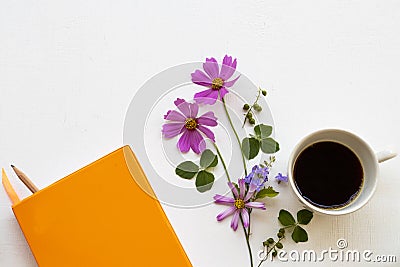 Notebook planner for business work with hot coffee espresso ,pink flowers cosmos Stock Photo