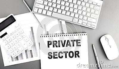 Notebook with private sector text, keyboard, calculator, charts, and mouse on a gray desk Stock Photo