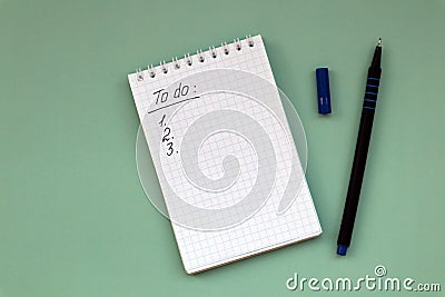 Notebook with to do list on green background and pen with copy space Stock Photo