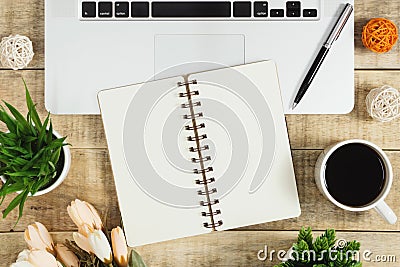 Notebook on top of laptop with coffee on wood background. Stock Photo