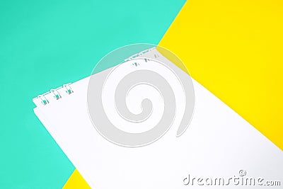 Notebook with white paper on multi-colored background With yellow and blue Stock Photo