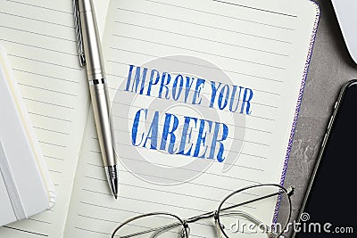 Notebook with words IMPROVE YOUR CAREER, pen and glasses on table Stock Photo